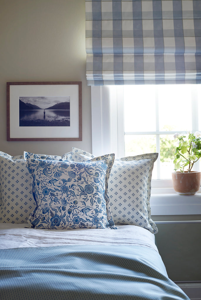 blue and white Gingham blind with floral and geometric pillows 